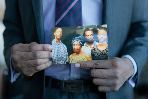 Andrea displays a photograph of himself with his father, grandmother, and sister. 