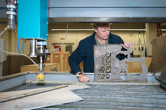 Looking at patterns cut from a steel plate using GBC�s waterjet cutter.