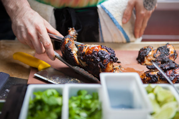 Aiden Tranquada prepping Patois' popular jerk chicken.