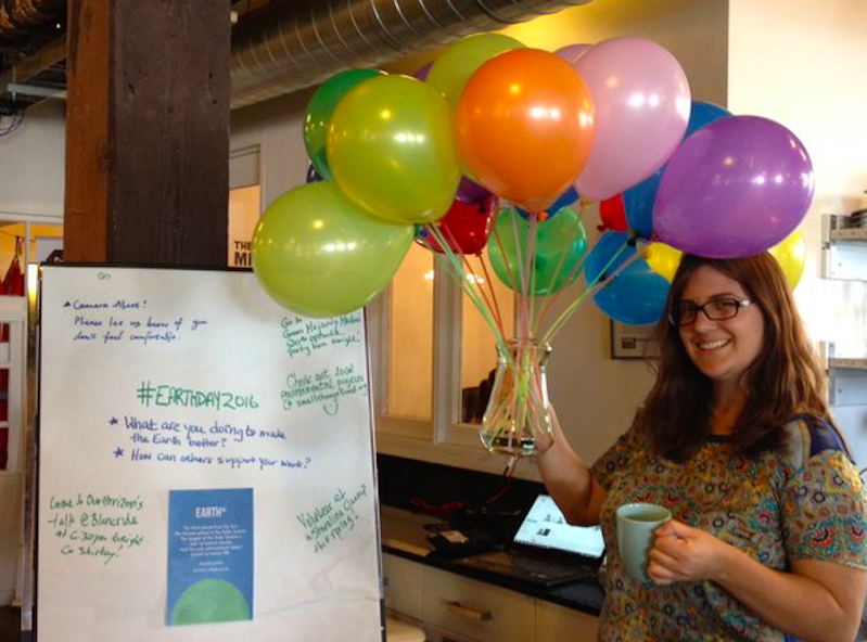 Victoria Alleyne of Full Footprint holds seventeen balloons, representing the 17 per cent reduction in carbon emissions gained from sustainable coffee. 