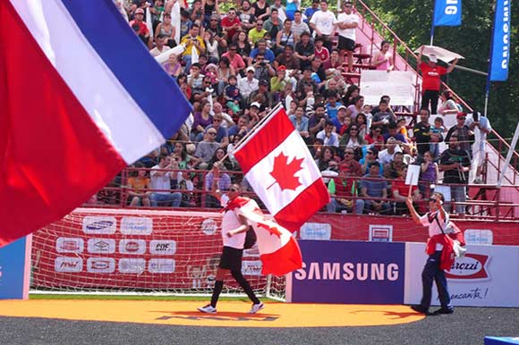 Alex Auger, holding a Canadian flag at the 2014 Homeless World Cup.