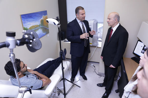  Jeff Daskalakis, a doctor from the Centre for Addiction and Mental Health, shows Innovation Minister Reza Moridi a brain scanning device, one of the projects that receiving funding from the province. 